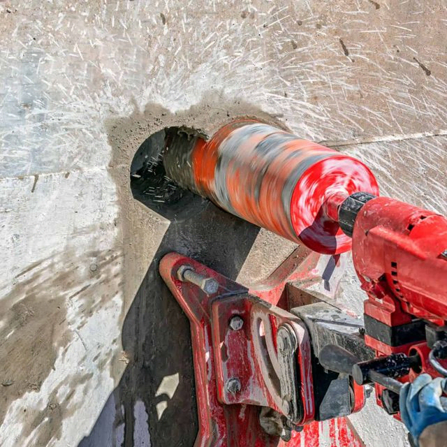 Arbeider borer betongvegg med kjernebormaskin